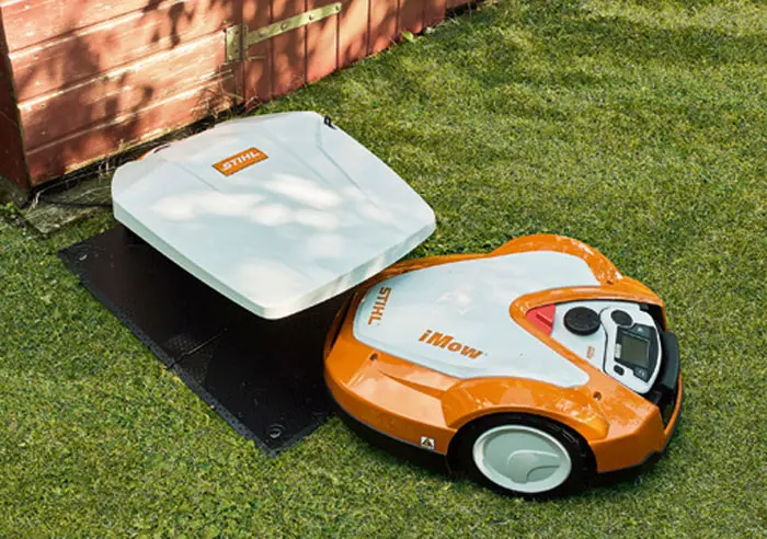 Ein Mähroboter von STIHL beim Aufladen an der Ladestation
